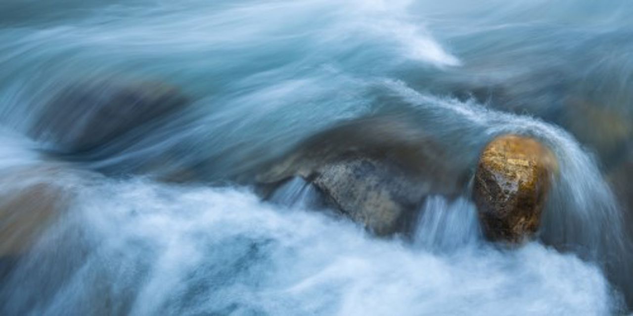 Wasser fließt und ein goldener Felsen im Fluss Tidong