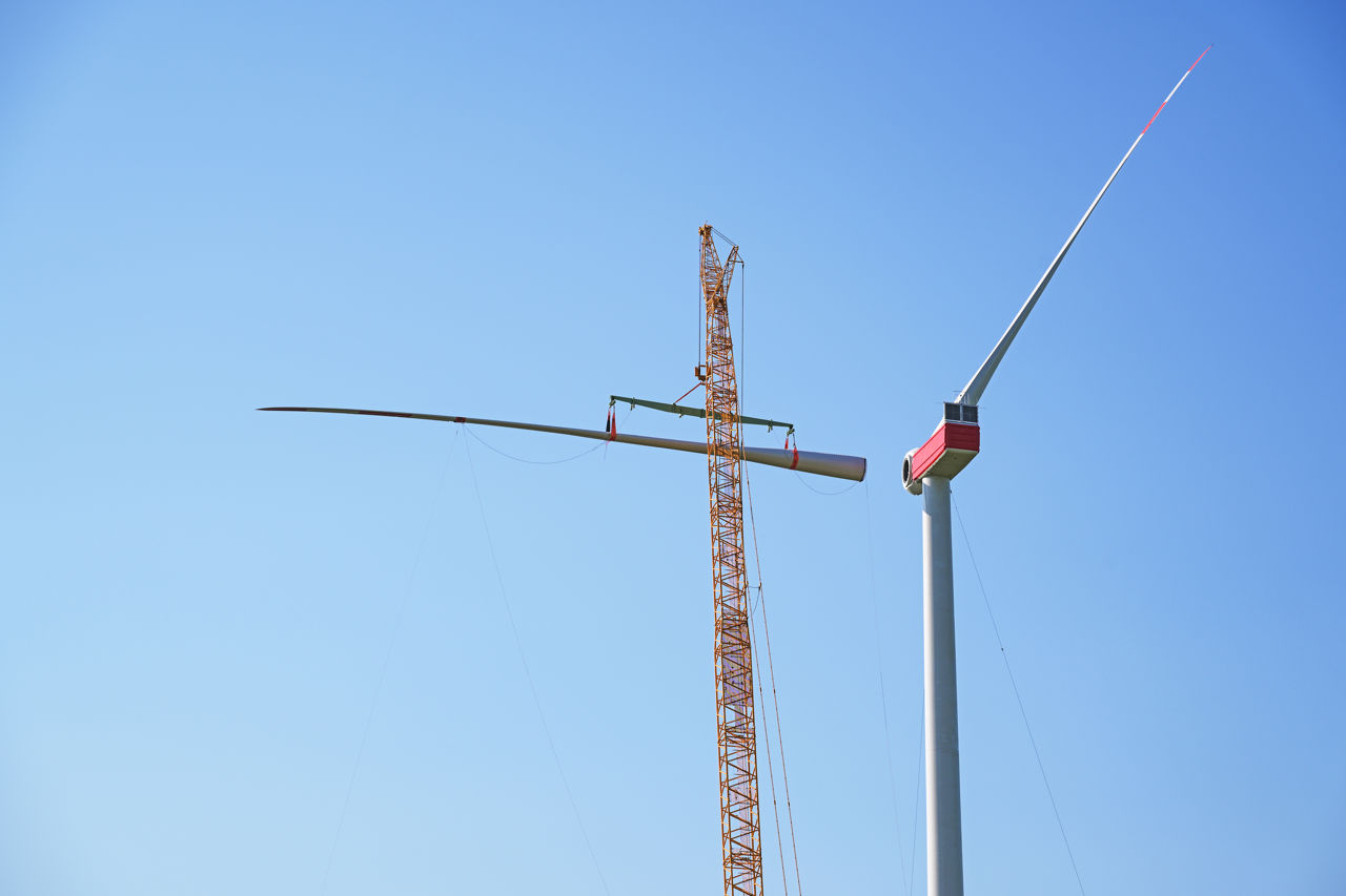 Das Rotorblatt einer Windturbine wird installiert.